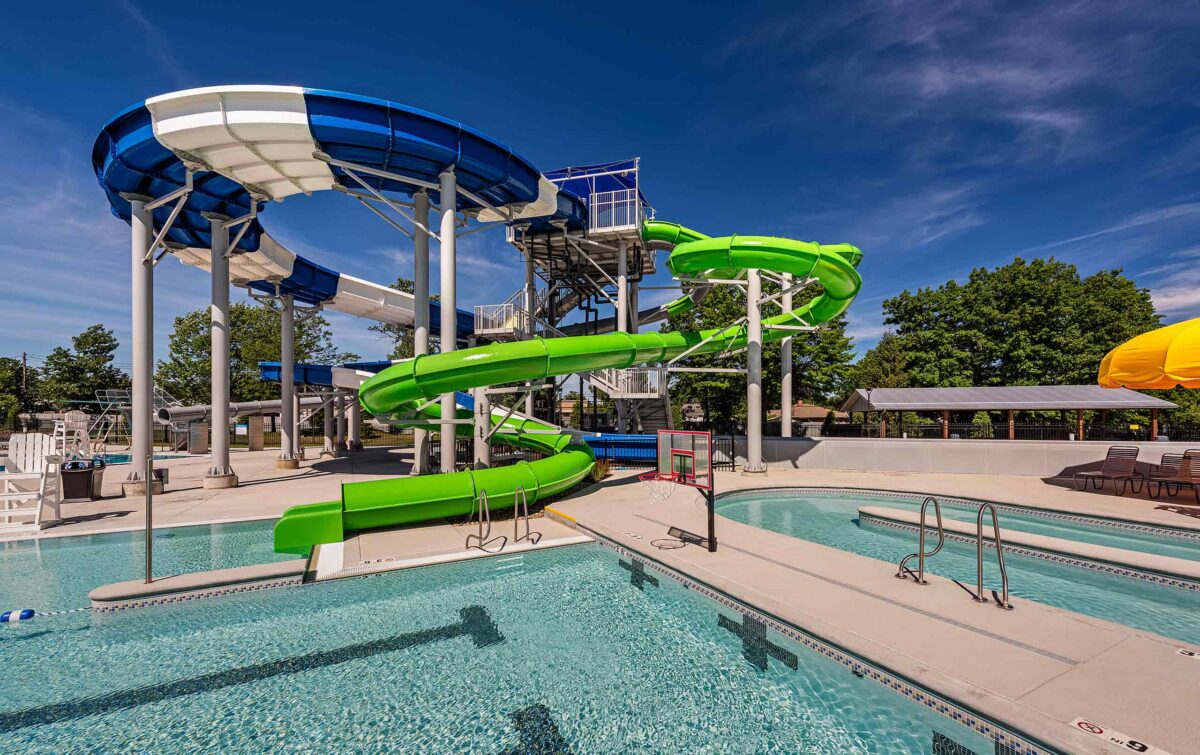 Outdoor aquatic center with blue/white and green waterslides