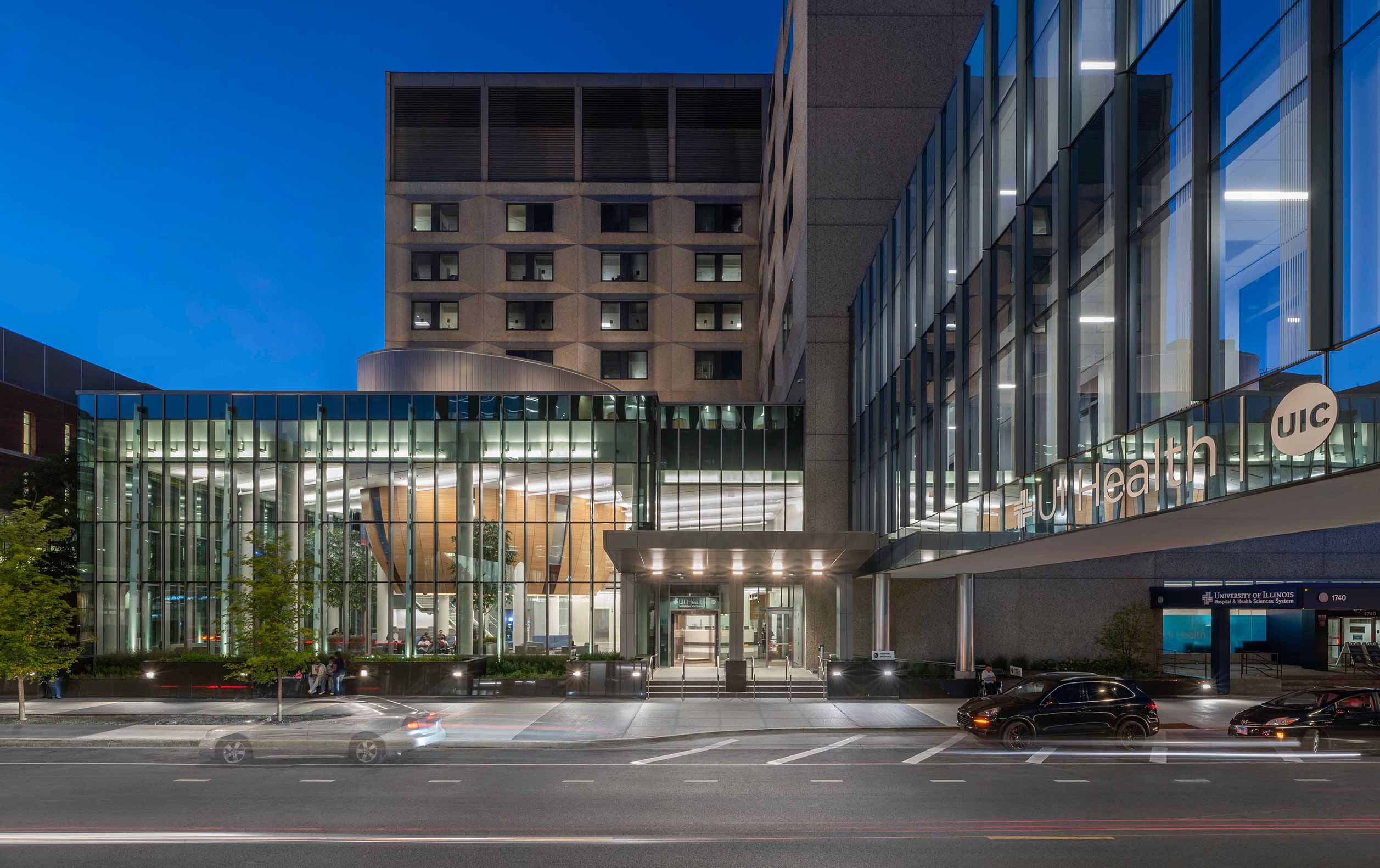 Exterior night view of glass wall displaying bowl-shaped wooden element inside