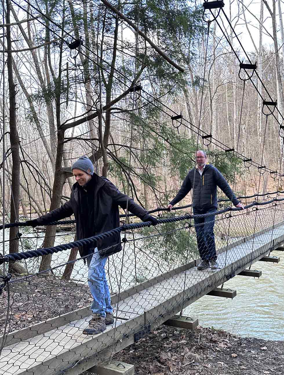 Architects crossing bridge over water