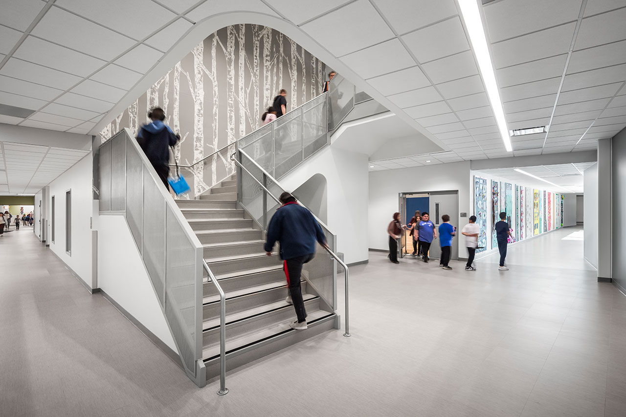 School atrium with staircase and birch tree wall decoration