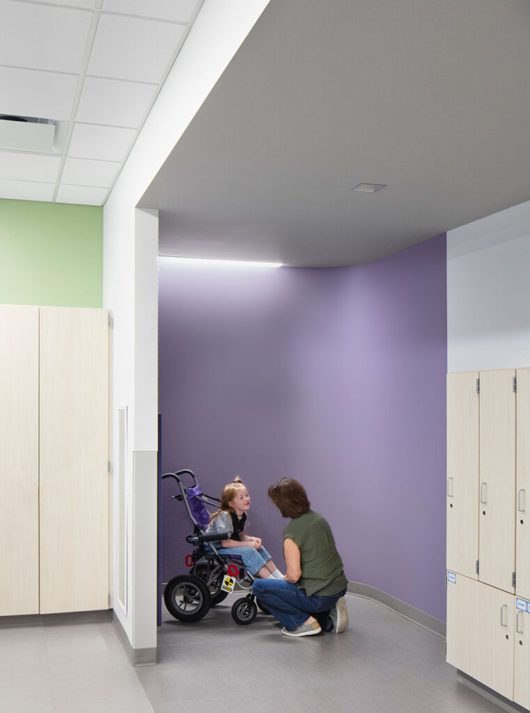 Teacher calming student in classroom nook.