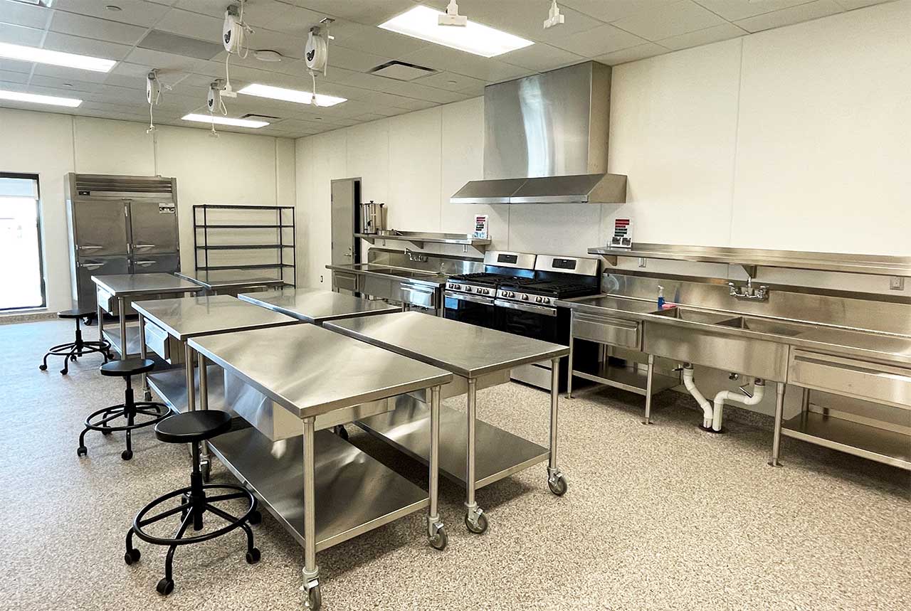 School room with metal tables, sinks, and other kitchen-related equipment