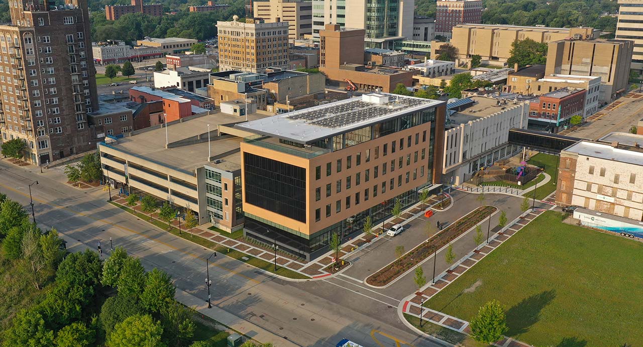 Aerial view of six-story rectangular building with large window wall.