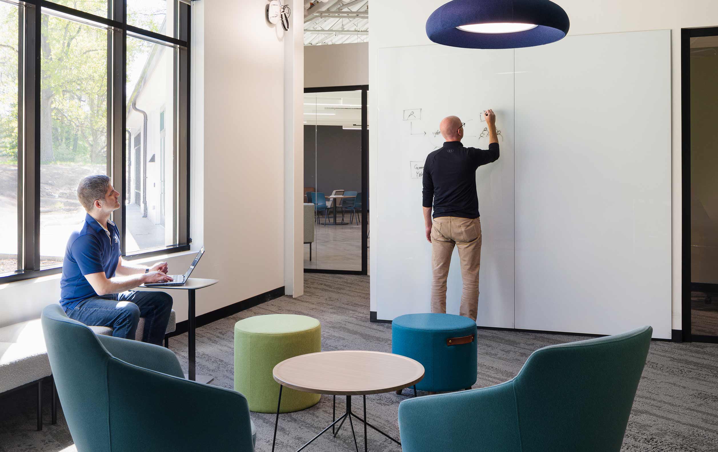 Office breakout area with person writing on wall