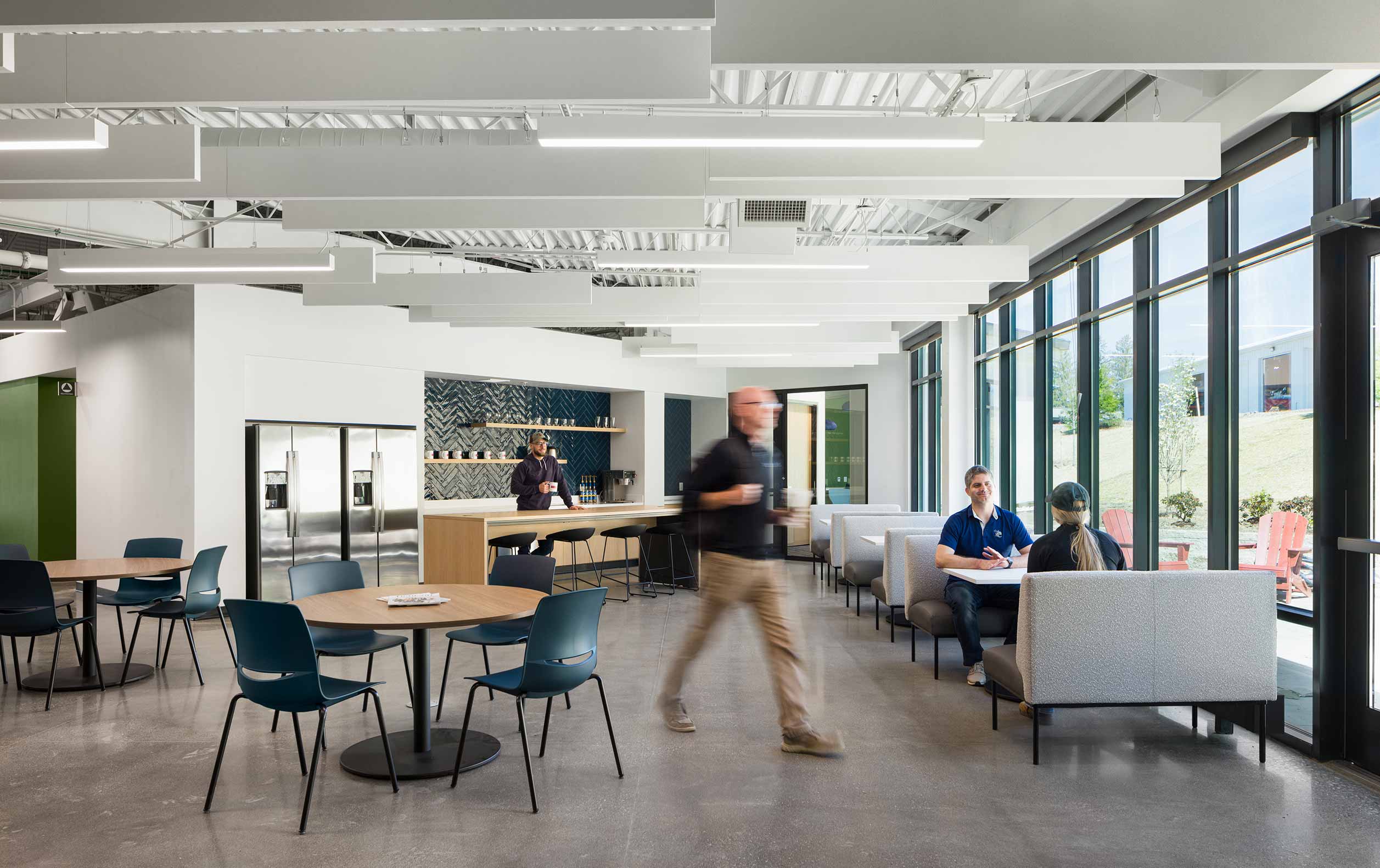 Break room with booths along window, tables, and high-top stools.