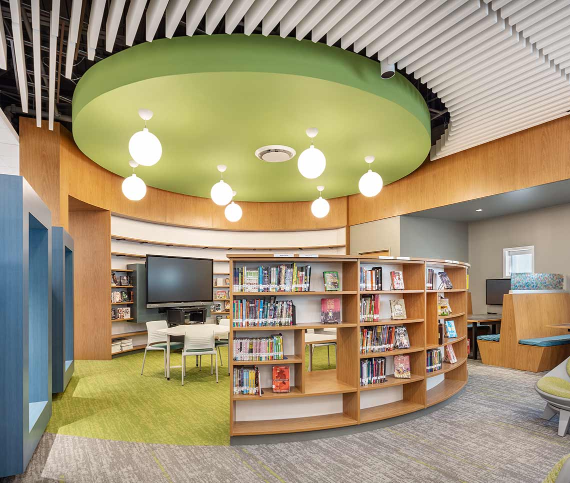 Elementary school library reading room with blue portals, circular green ceiling and green carpet