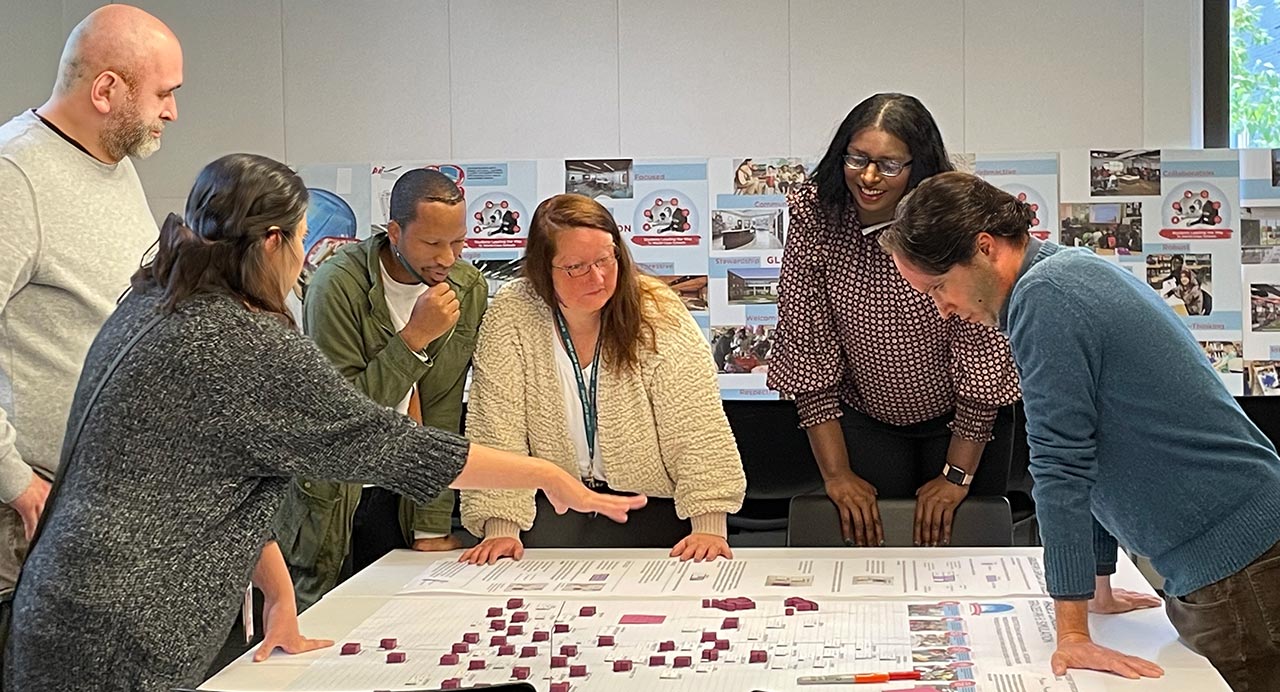 Illinois school district leaders standing around a facilities map