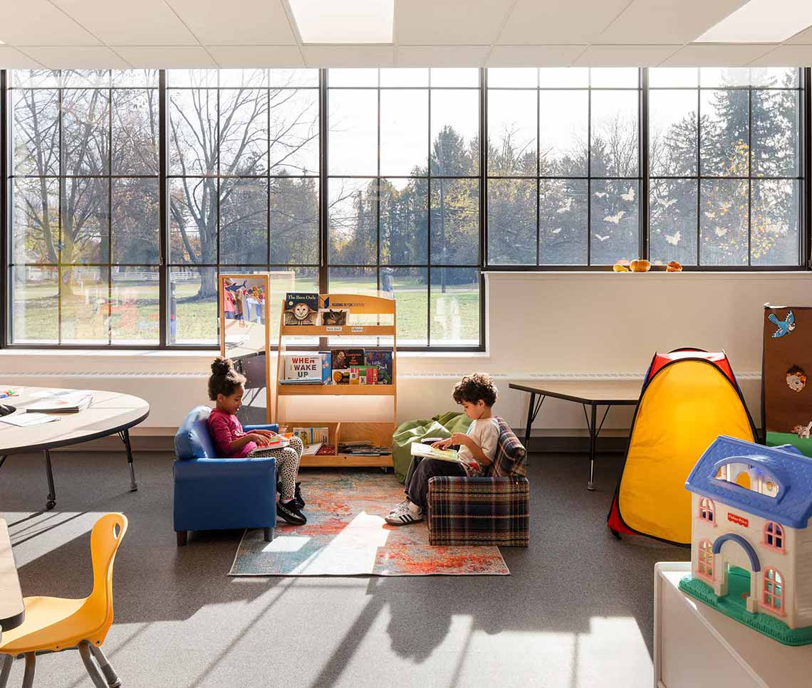 Preschool classroom with students and large window